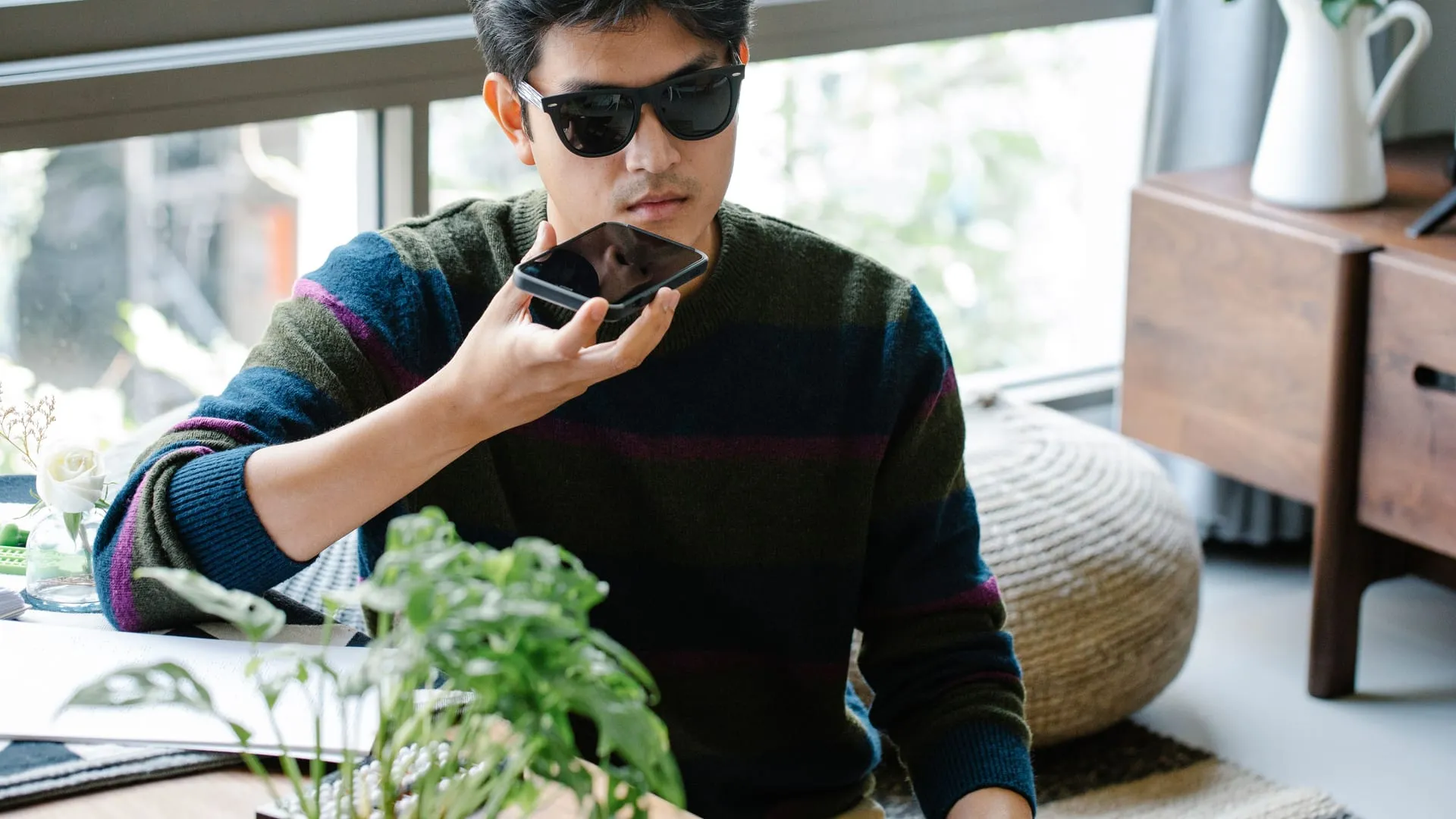 Man speaking into his phone at home