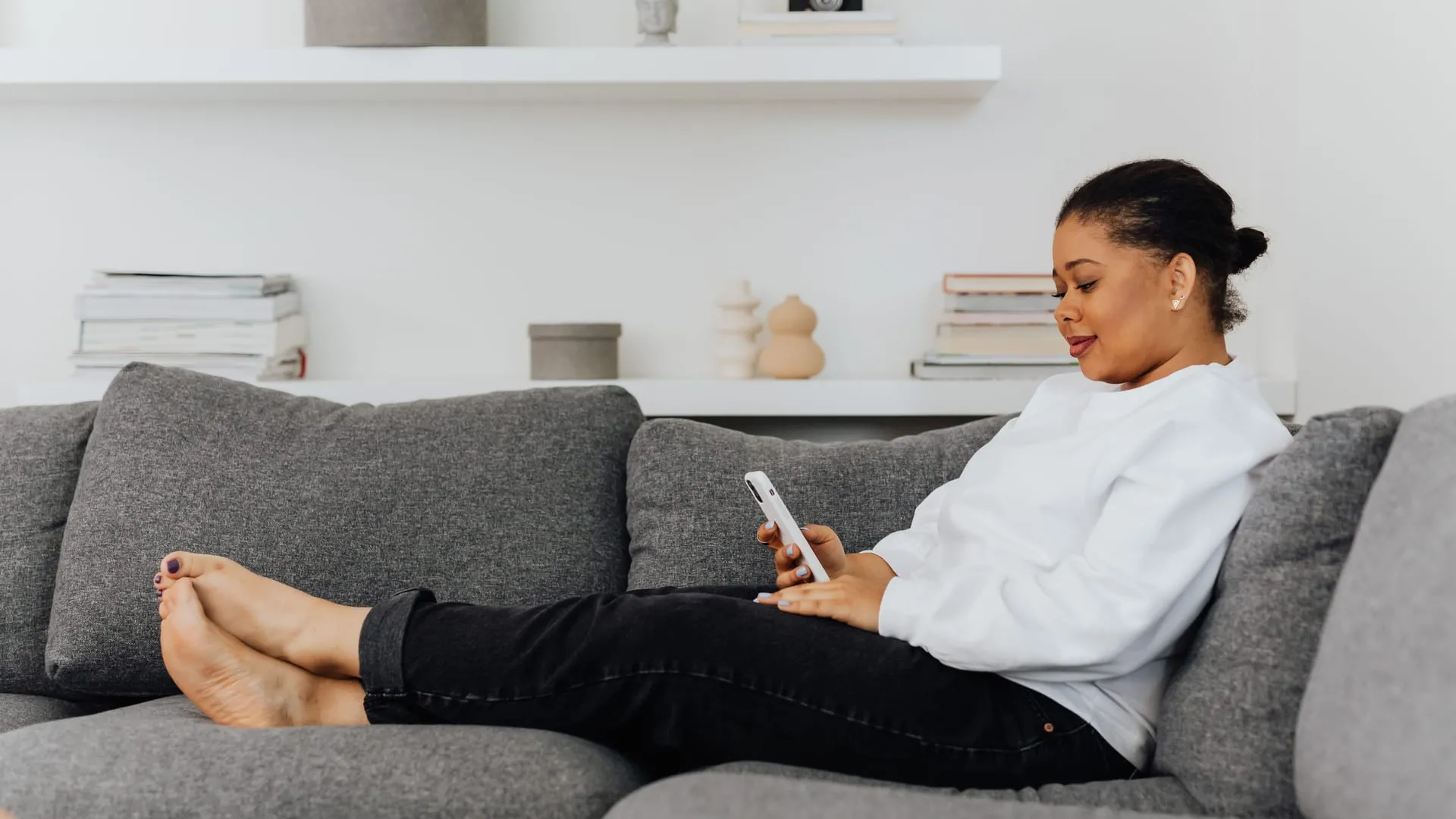 Woman relaxing on a sofa using an app on her phone